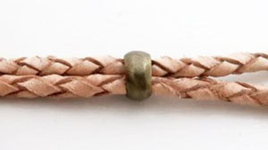 両端の穴の大きさが違う、紐を締めるメタルビーズに適合する革紐の例